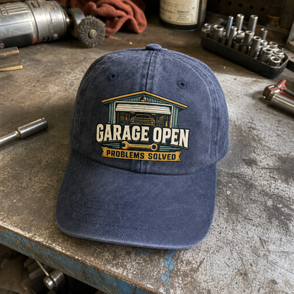 Blue vintage washed cap with printed Garage Open Problems Solved design, angled view