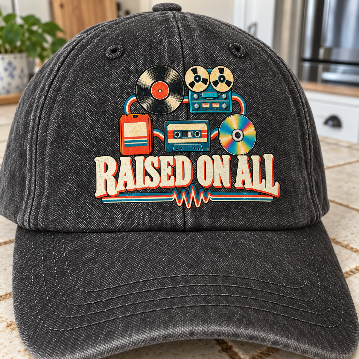 Front view of black vintage washed cap with printed Raised On All retro music design