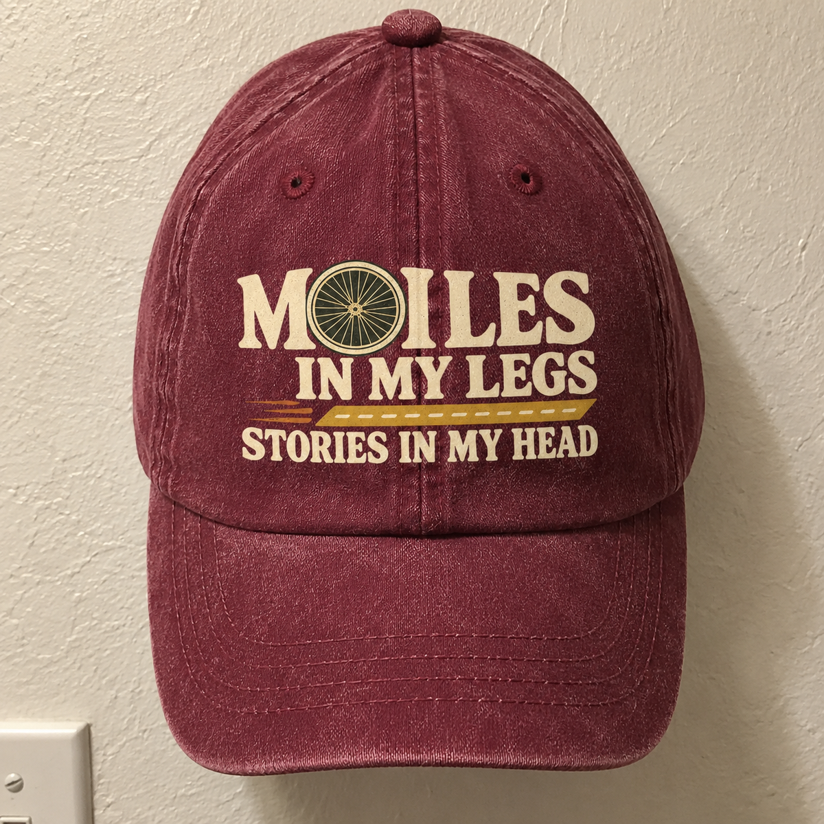 Burgundy vintage washed cap with printed Miles In My Legs slogan, front angle