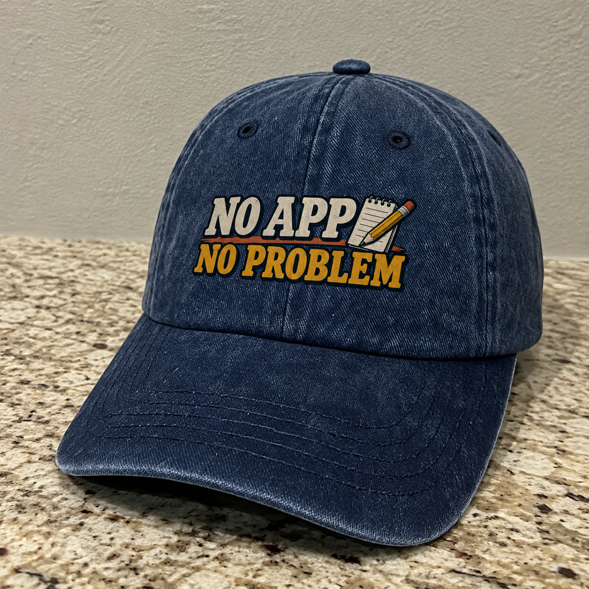 Navy vintage washed cap with printed “NO APP NO PROBLEM” slogan, angled front view