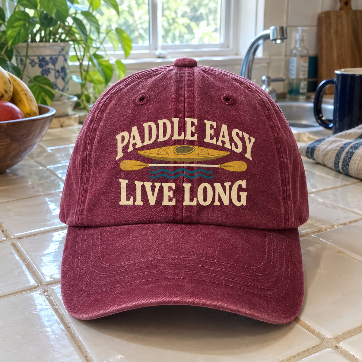 Burgundy vintage washed cap with printed Paddle Easy Live Long kayak design, front angle