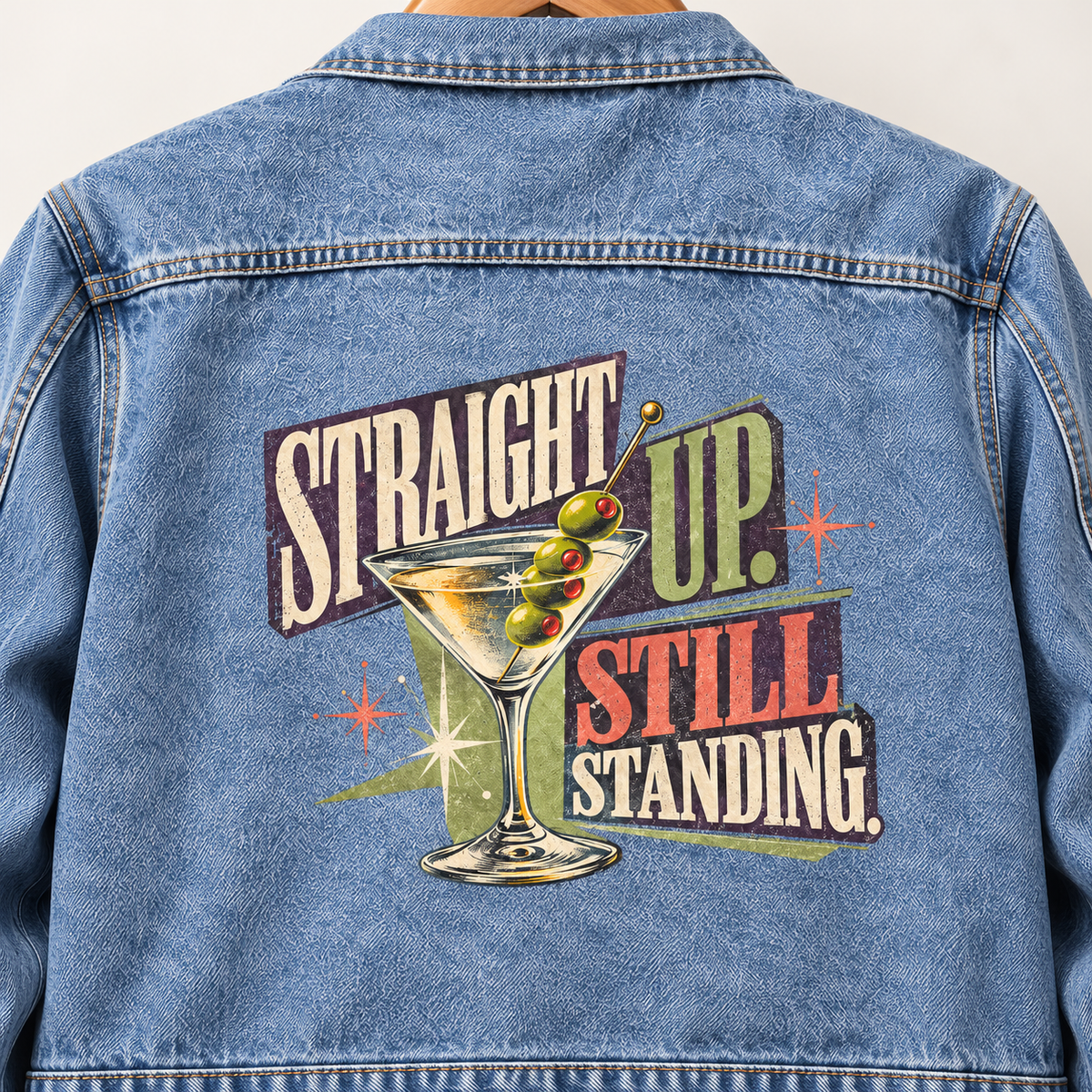 Blue vintage denim jacket, back view, with printed martini and Straight Up. Still Standing slogan