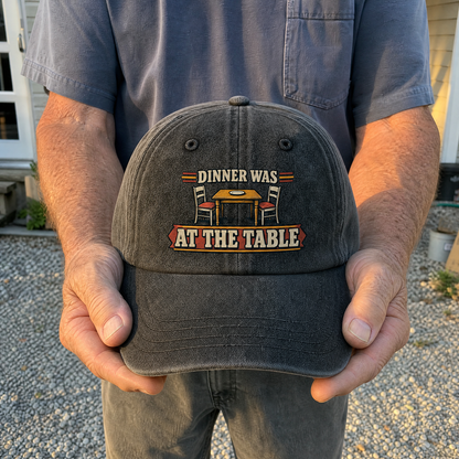 Vintage washed cap with printed “Dinner Was At The Table” held by an older man.