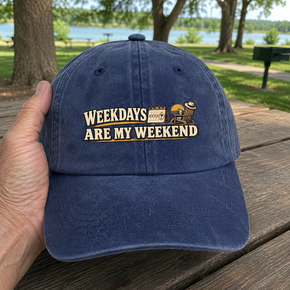 Navy vintage washed cap with printed Weekdays Are My Weekend slogan held outdoors