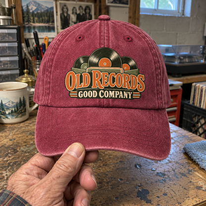 Handheld burgundy vintage washed cap with printed Old Records Good Company vinyl design