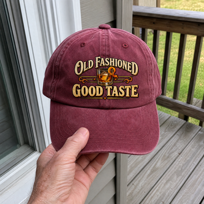 Maroon vintage washed cap with printed Old Fashioned Good Taste design, handheld front view