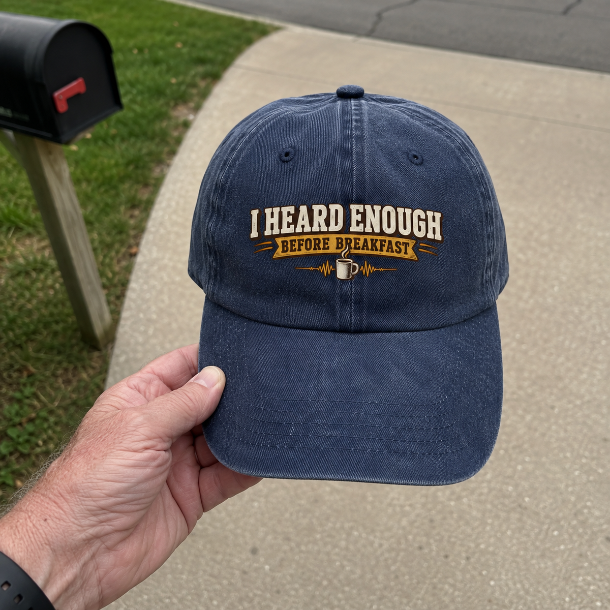 Hand holding vintage washed cap with I Heard Enough Before Breakfast printed design