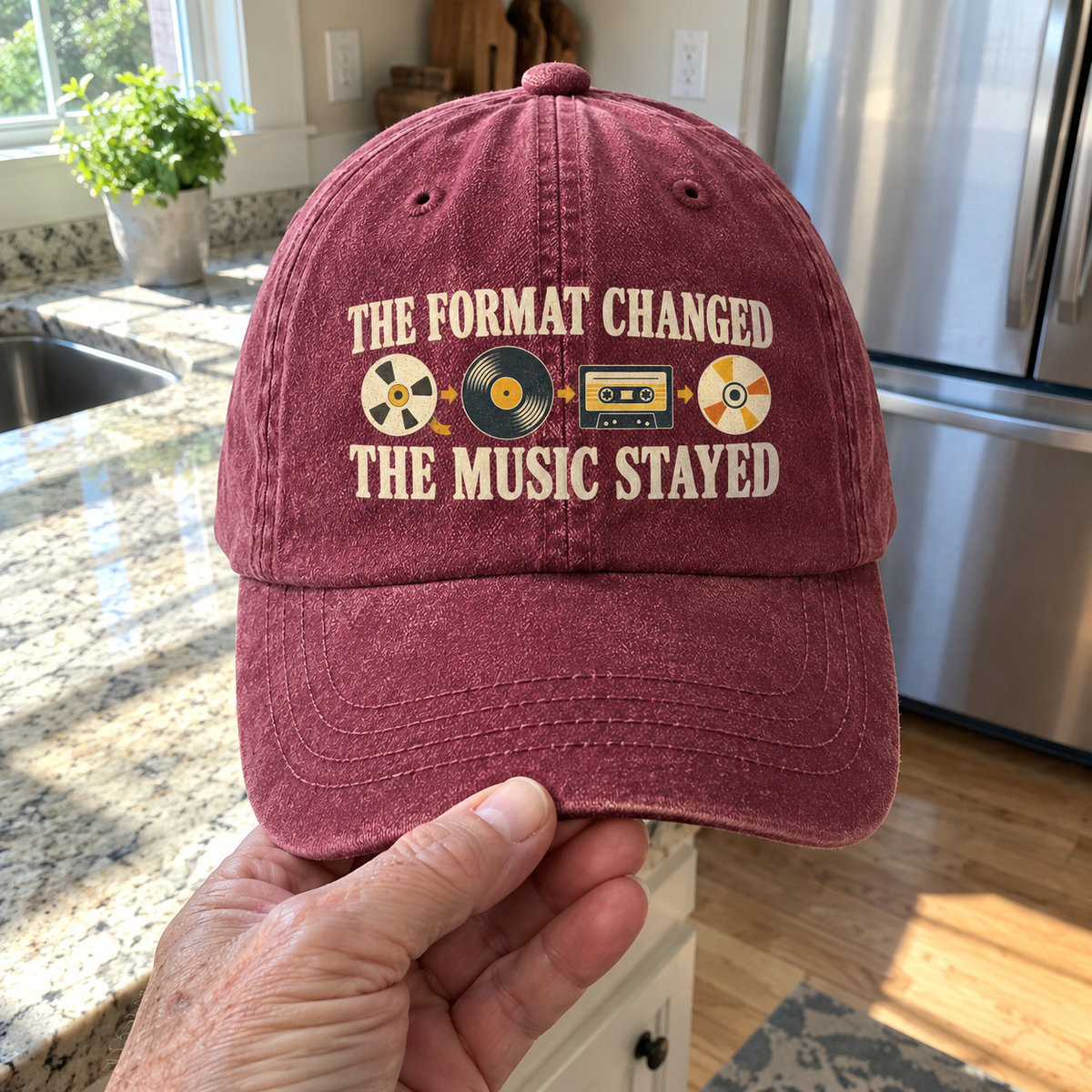 Burgundy vintage washed cap with printed “The Format Changed The Music Stayed” design, handheld front view