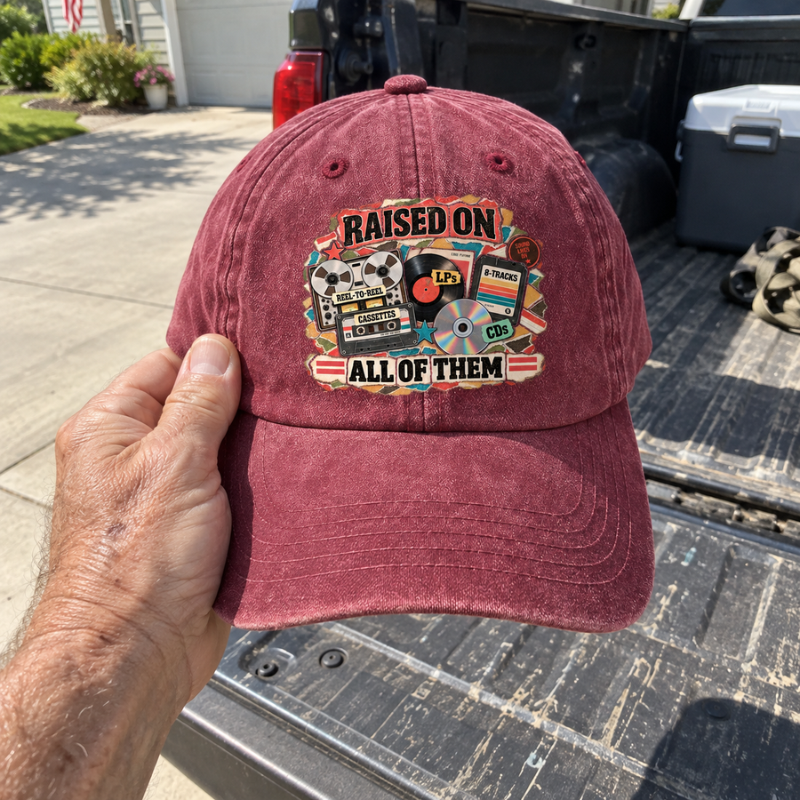 Handheld burgundy vintage washed cap with printed Raised On All Of Them design