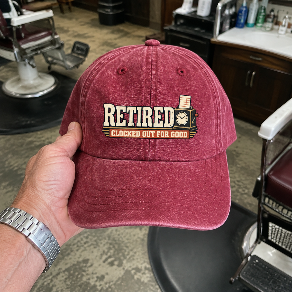 Burgundy vintage washed cap with printed Clocked Out For Good slogan held by hand