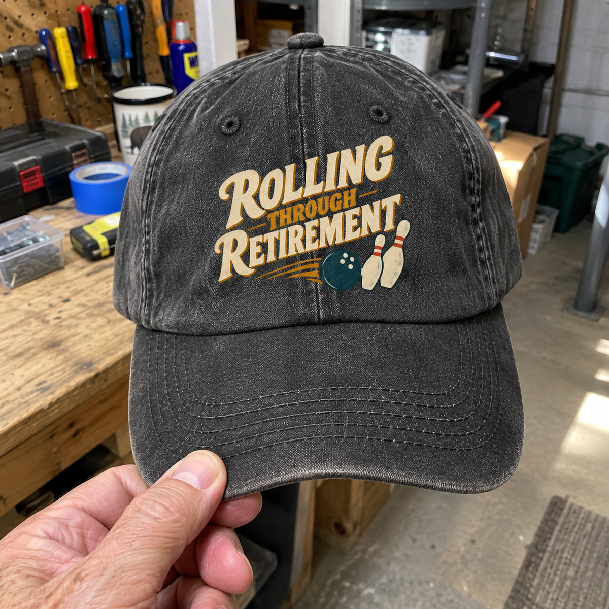 Black vintage washed cap with printed Rolling Through Retirement slogan and bowling design, handheld front view