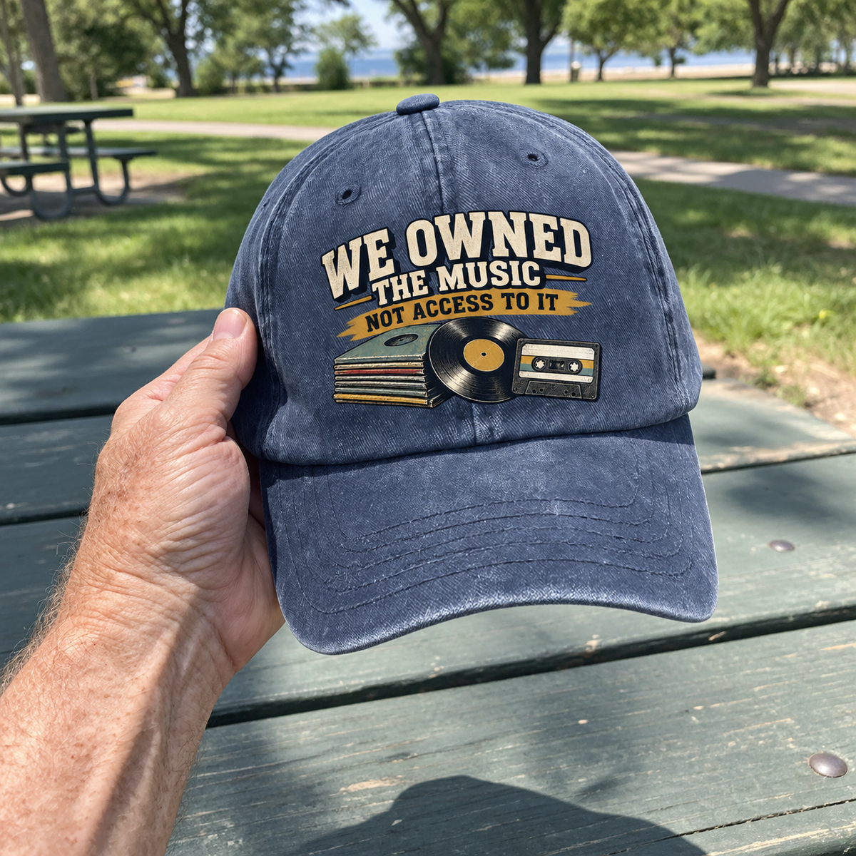 Navy vintage washed cap with printed music slogan and retro records, handheld in park