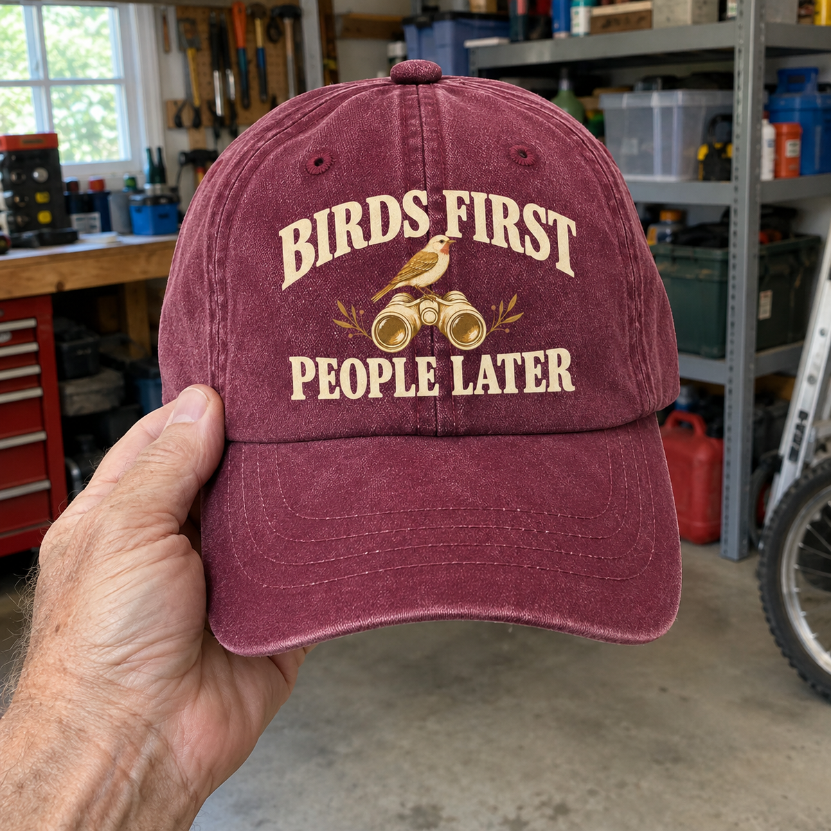 Maroon vintage washed cap with printed Birds First. People Later slogan, handheld front view