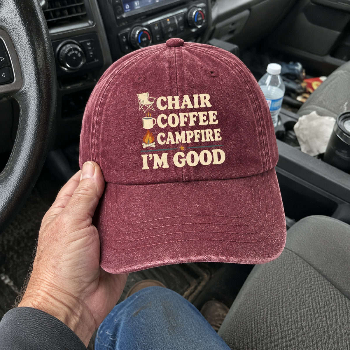 Hand holding vintage washed cap with Chair Coffee Campfire. I'm Good printed design