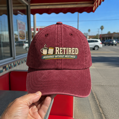 Burgundy vintage washed cap with printed Retired Mornings Without Meetings design, handheld view