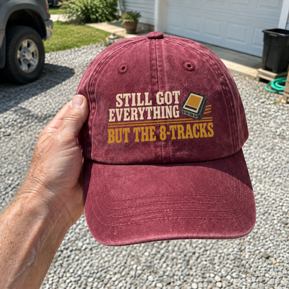 Burgundy vintage washed cap printed with Still Got Everything But The 8-Tracks slogan, handheld view