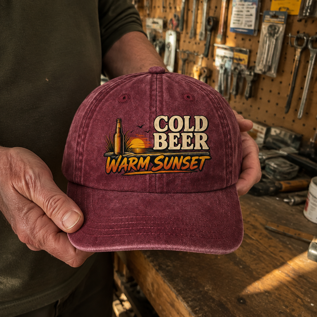 Burgundy vintage washed cap with printed Cold Beer Warm Sunset design, handheld view