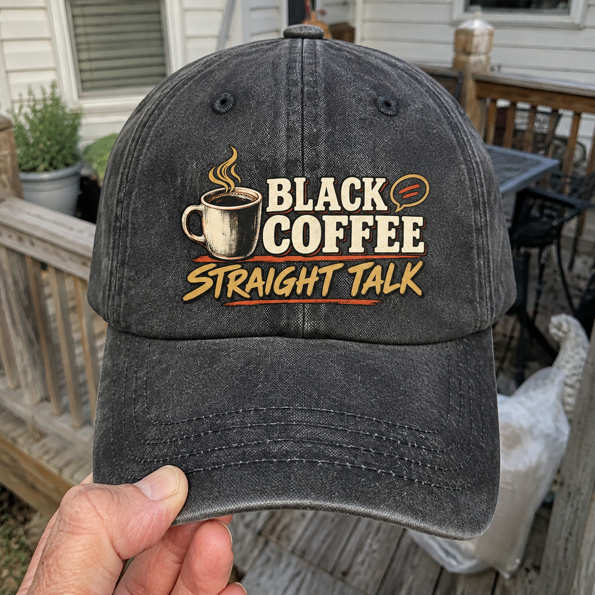 Hand holding vintage washed cap with Black Coffee. Straight Talk printed design