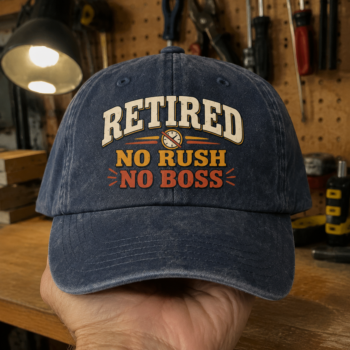 Navy vintage washed cap with printed Retired No Rush No Boss slogan held by hand