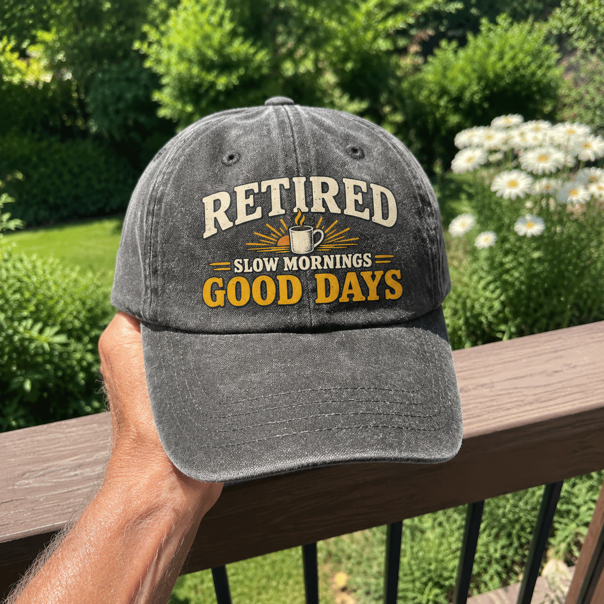 Vintage washed cap printed with “Retired Slow Mornings Good Days,” handheld outdoors.