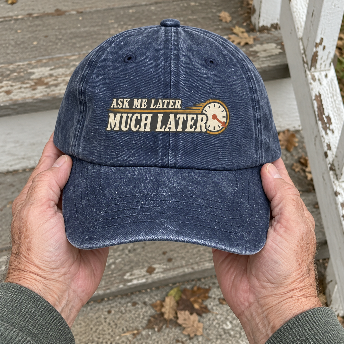 Navy vintage washed cap held outdoors, printed Ask Me Later Much Later with clock.