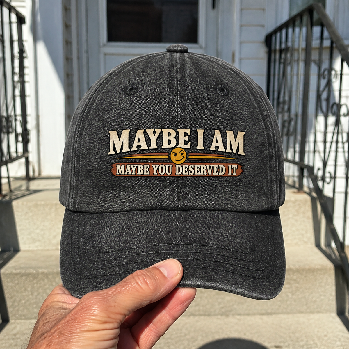 Black vintage washed cap with printed Maybe I Am slogan, handheld view