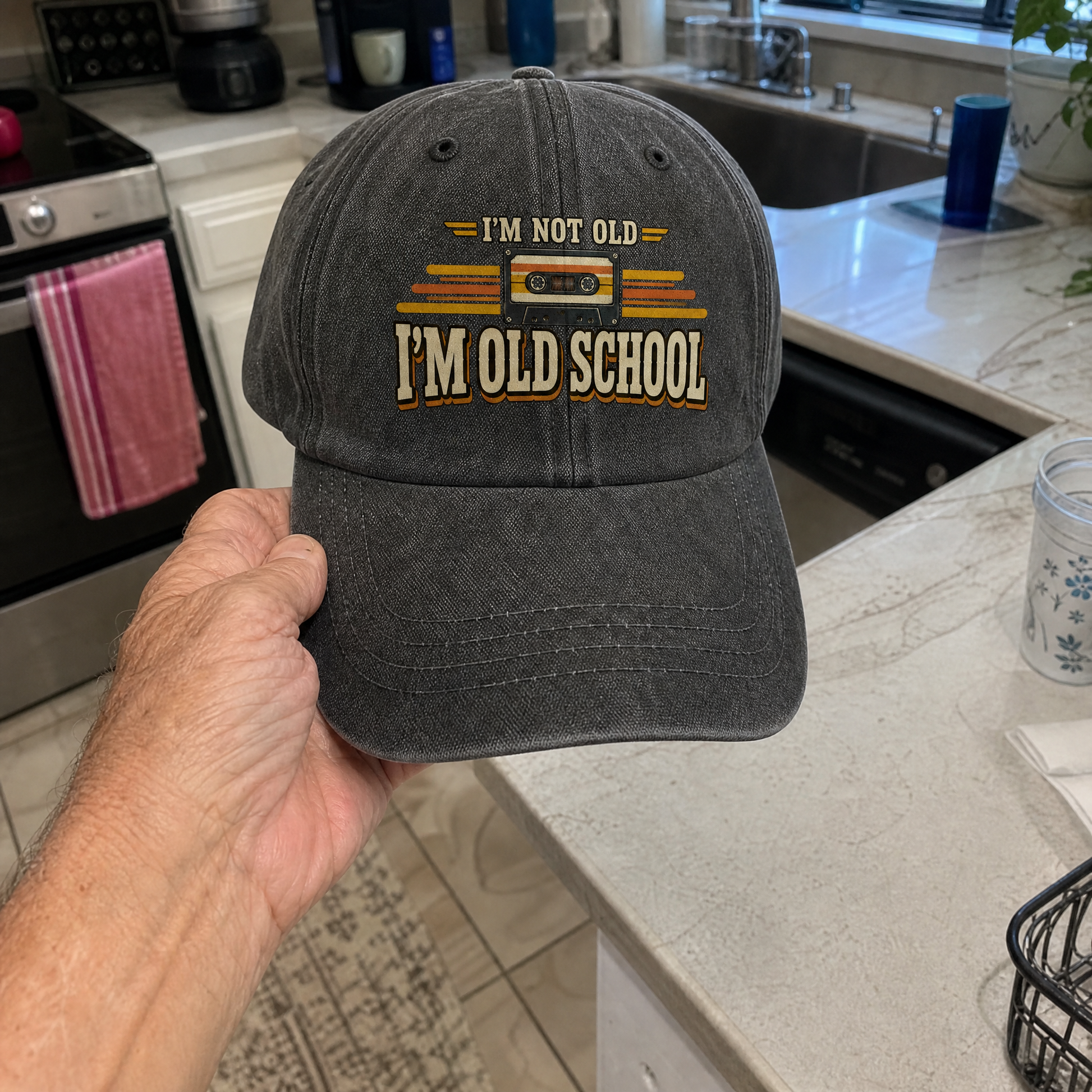 Vintage washed cap with printed “41 I’m Old School” design, handheld view.