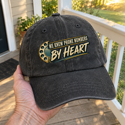 Black vintage washed cap with printed We Knew Phone Numbers By Heart, held in hand.