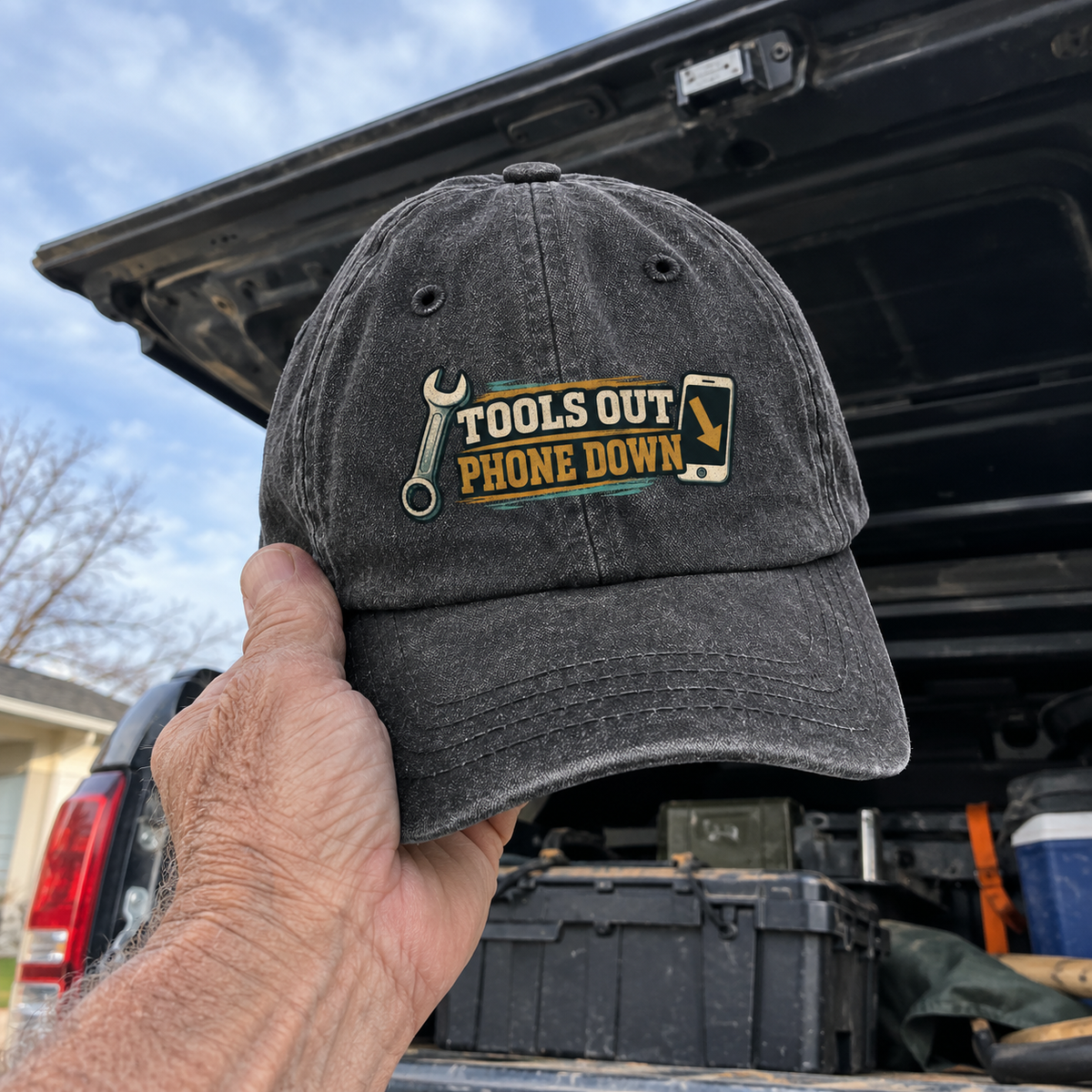 Dark gray vintage washed cap with printed Tools Out. Phone Down slogan, handheld outdoors