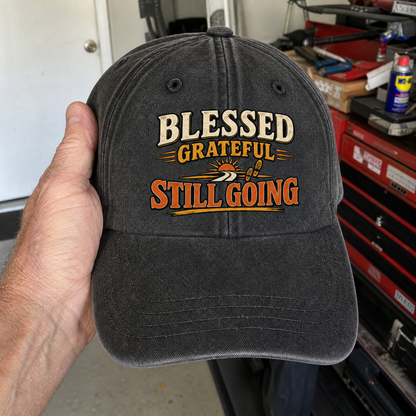 Black vintage washed cap with printed Blessed Grateful Still Going slogan, handheld view