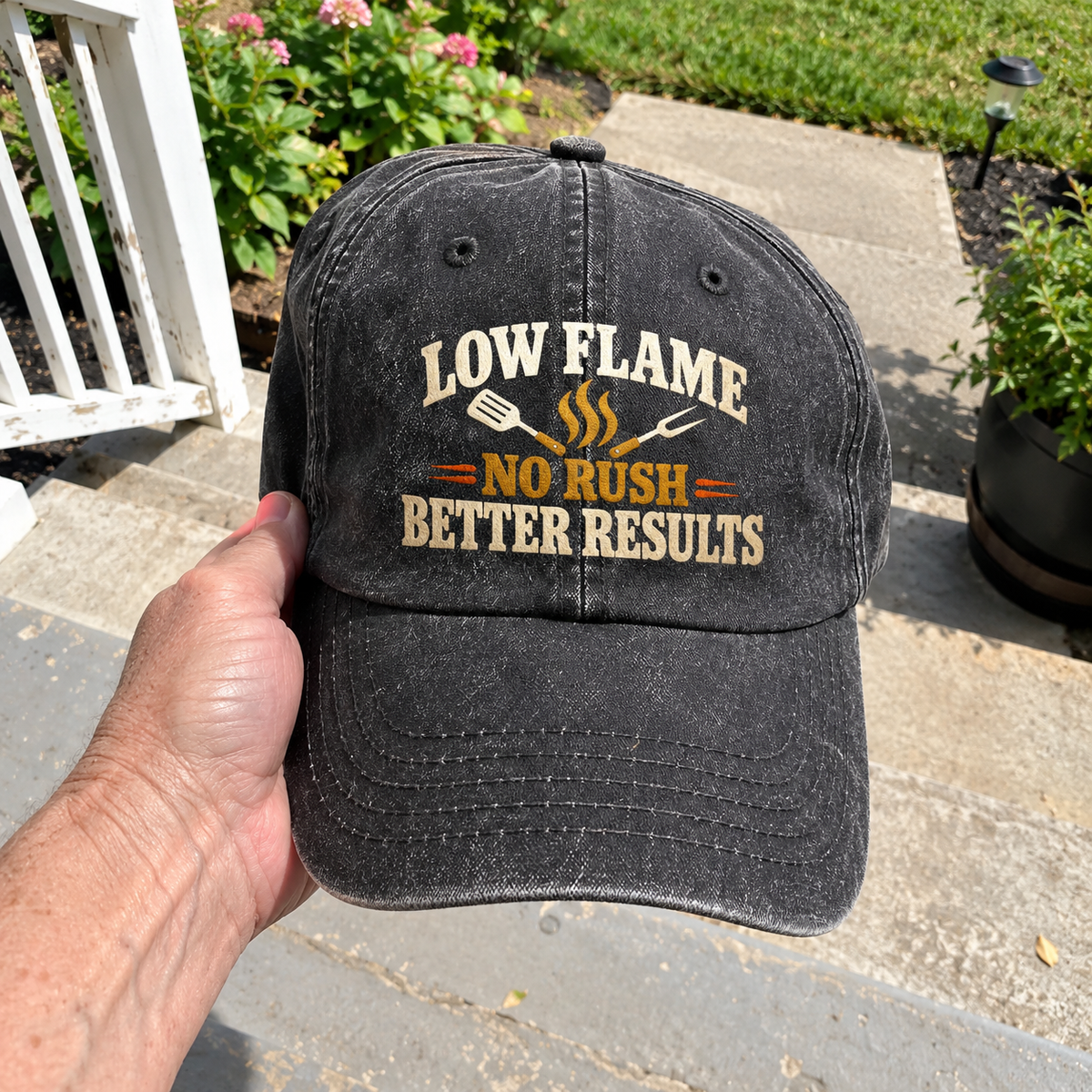 Handheld black vintage washed cap with printed Low Flame No Rush Better Results slogan