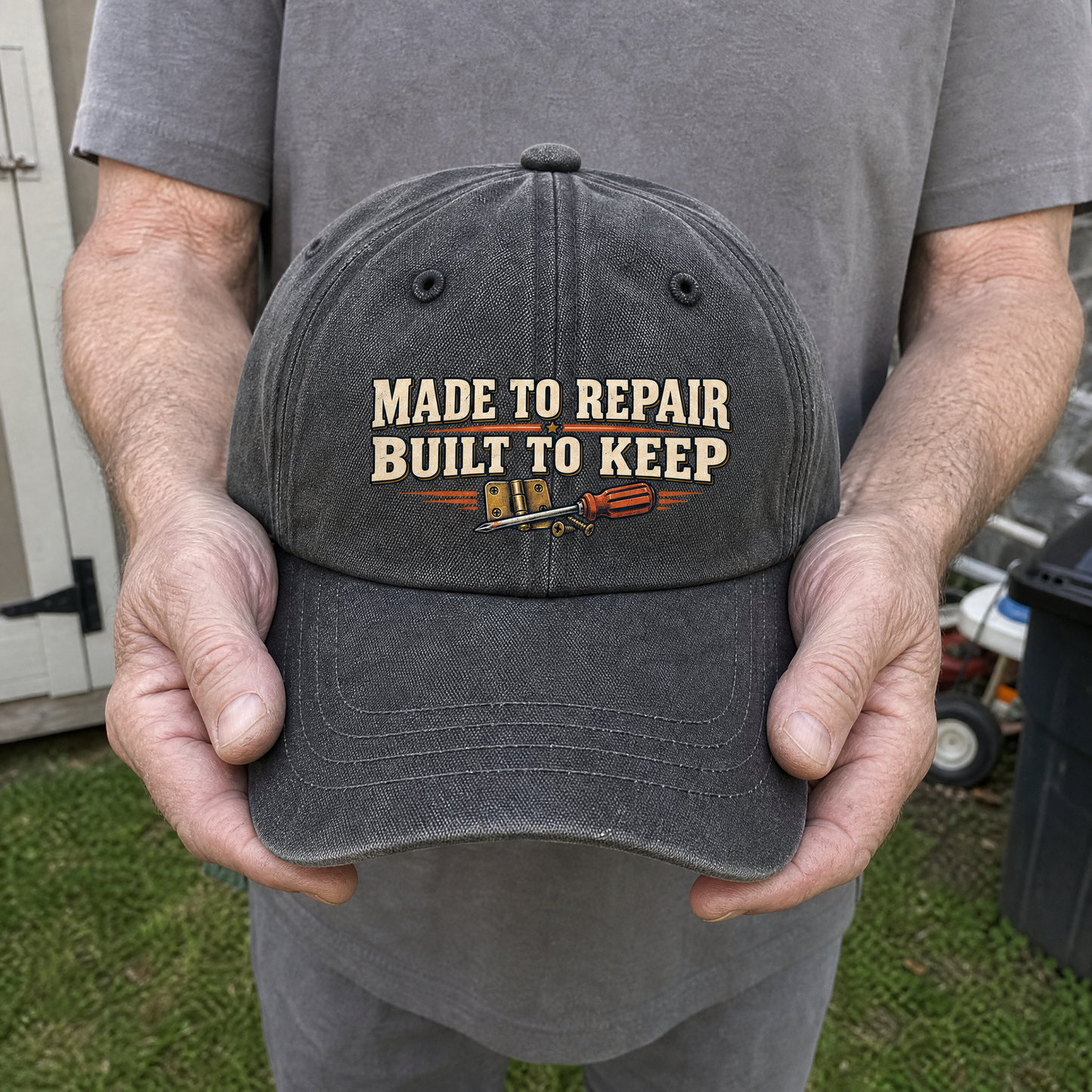Gray vintage washed cap with printed Made To Repair Built To Keep slogan, handheld view