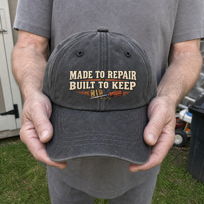 Gray vintage washed cap with printed Made To Repair Built To Keep slogan, handheld view