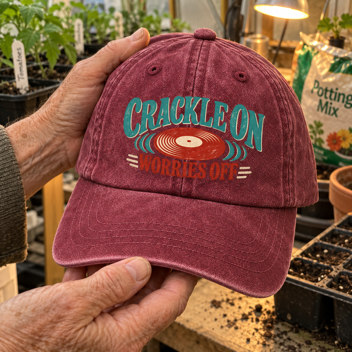 Handheld burgundy vintage washed cap with printed Crackle On Worries Off record design