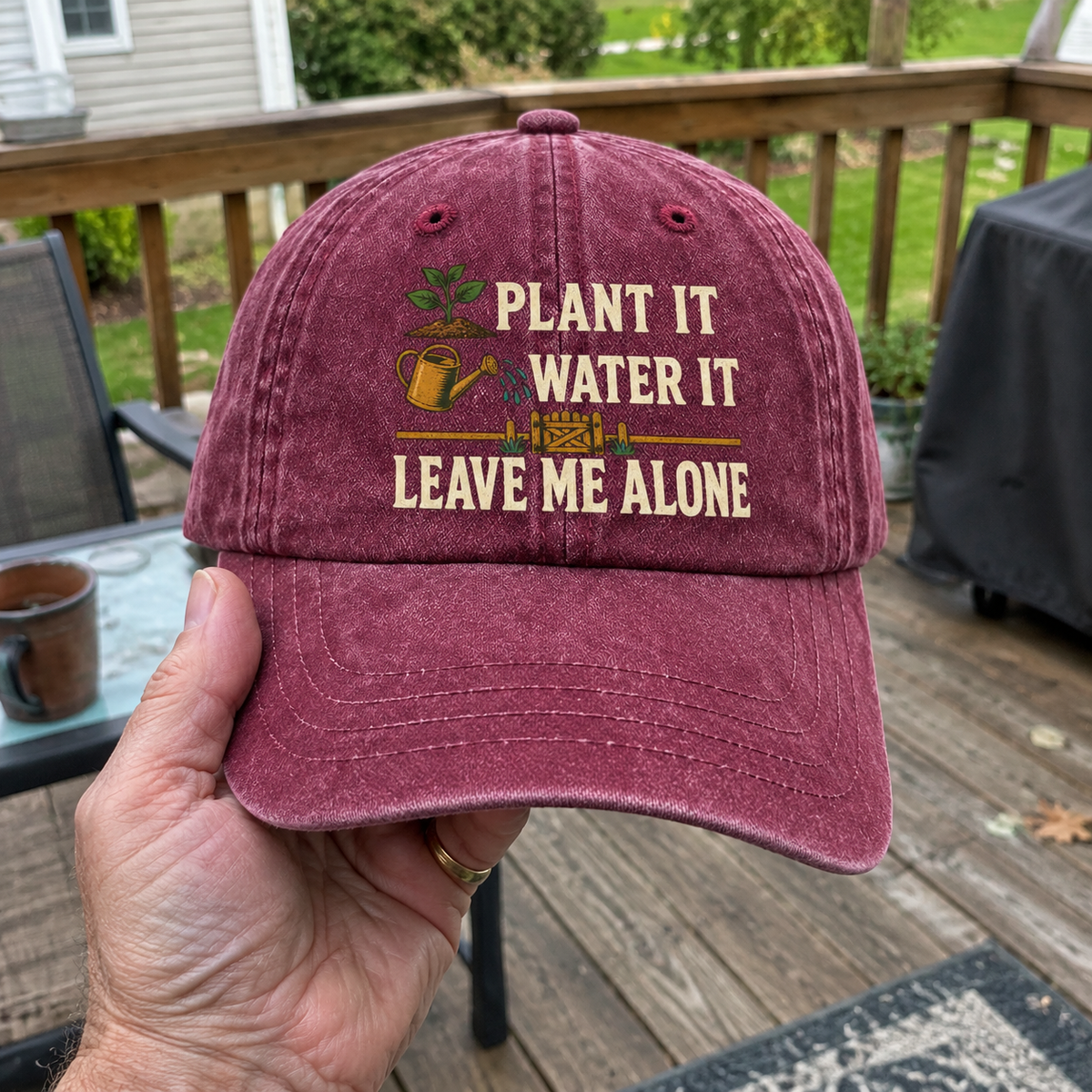 Maroon vintage washed cap with printed Plant It Water It Leave Me Alone slogan, handheld
