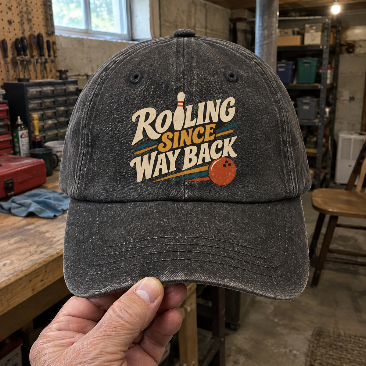 Vintage washed cap in charcoal gray with printed Rolling Since Way Back bowling design, handheld front view