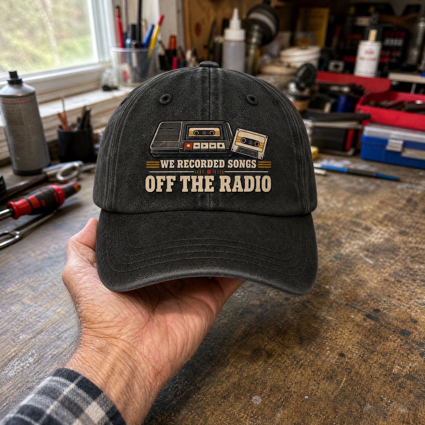 Black vintage washed cap with printed “We Recorded Songs Off The Radio” slogan, handheld front view