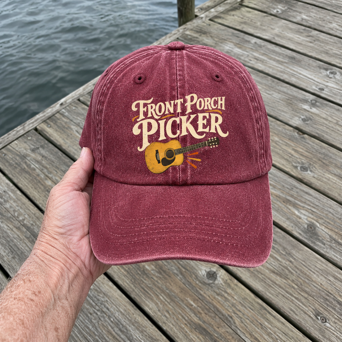 Burgundy vintage washed cap with printed Front Porch Picker guitar design, handheld front view