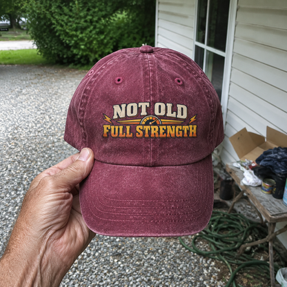 Burgundy vintage washed cap with printed Not Old Full Strength slogan, handheld view