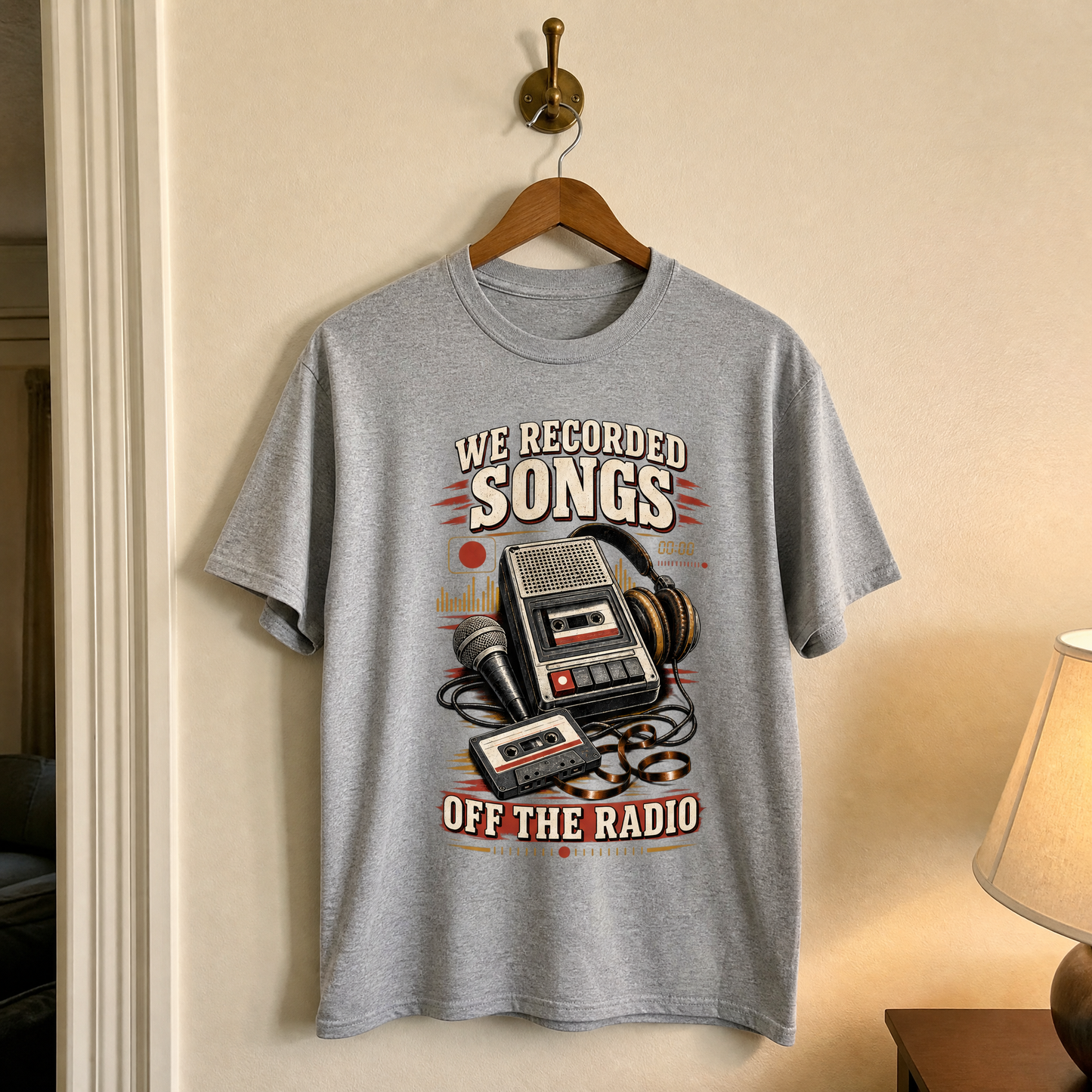 Gray vintage t-shirt hanging with printed “We Recorded Songs Off The Radio” retro cassette design