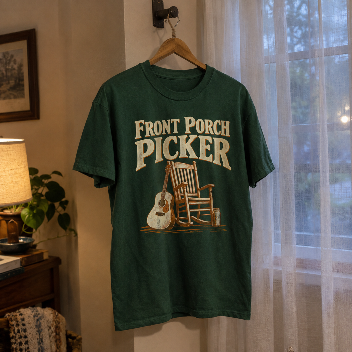 Green vintage t-shirt hanging with printed Front Porch Picker rocking chair and guitar design