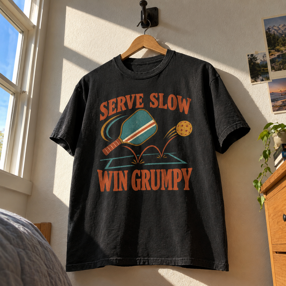 Black vintage t-shirt hanging with Serve Slow Win Grumpy printed paddleball design