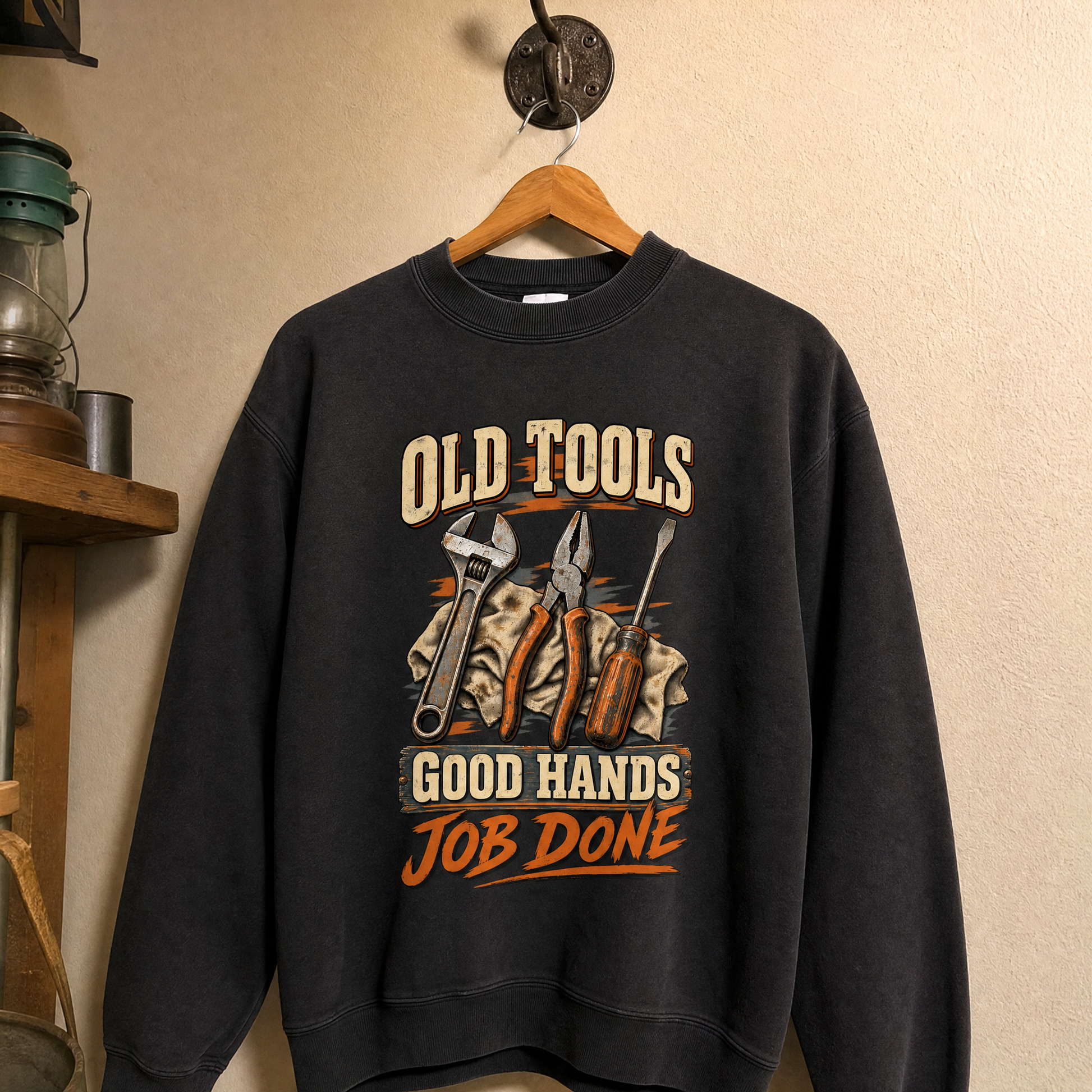 Black vintage sweatshirt hanging with printed Old Tools Good Hands Job Done design and tools.
