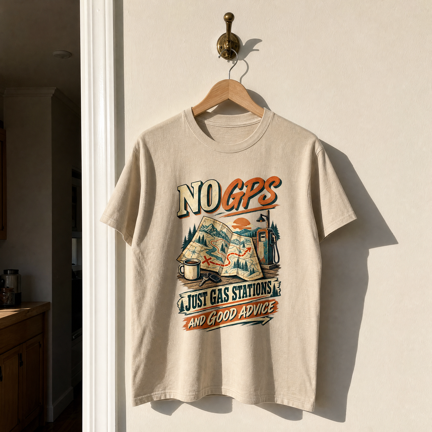 Beige vintage t-shirt hanging with printed No GPS Just Gas Stations And Good Advice slogan