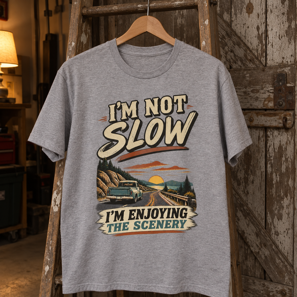 Gray vintage t-shirt hanging with printed pickup truck and I'm Not Slow I'm Enjoying The Scenery slogan.