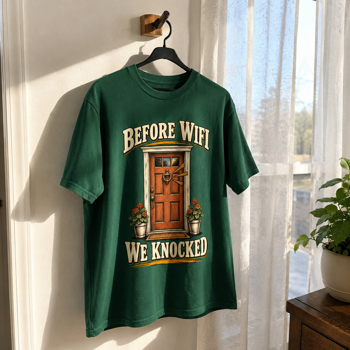 Green vintage t-shirt hanging with printed “Before Wifi We Knocked” door design