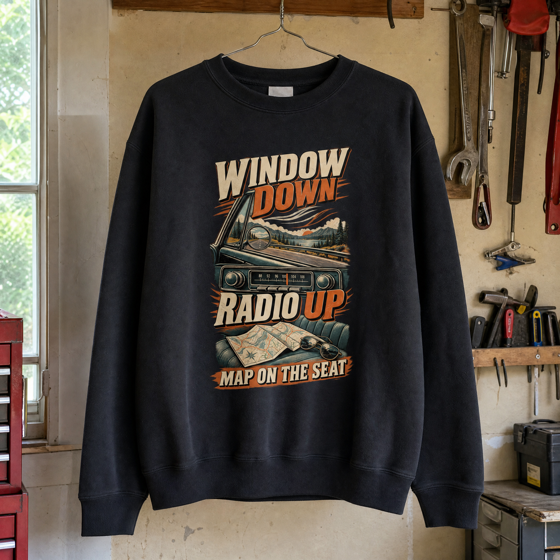Black vintage sweatshirt hanging, printed “Window Down Radio Up. Map On The Seat” design.