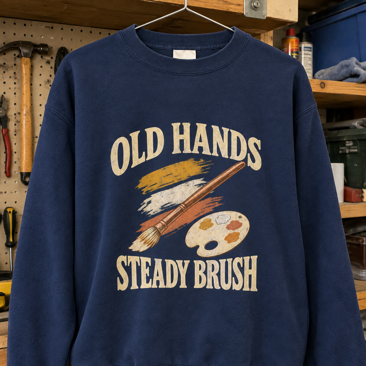 Navy vintage sweatshirt hanging with printed Old Hands Steady Brush slogan and paintbrush design