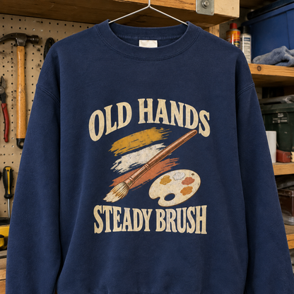 Navy vintage sweatshirt hanging with printed Old Hands Steady Brush slogan and paintbrush design