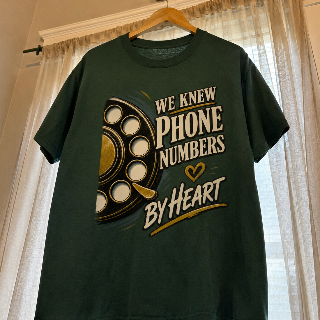 Dark green vintage t-shirt with printed We Knew Phone Numbers By Heart slogan, hanging.